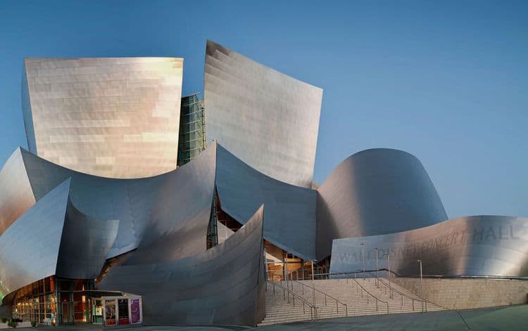 Walt Disney Concert Hall & VHB Tape Series
The iconic Walt Disney Concert Hall in Los Angeles uses 3M VHB double-sided tape to attach the exterior stainless steel cladding panels to aluminum clips behind the façade.
Each 4-by-10 ft panel was field-formed and bonded using VHB Tape instead of screws or welds, helping deliver a sleek, seamless aesthetic. 
3M states that their tape “plays a role” in holding the metal cladding together through thermal and wind stresses.

