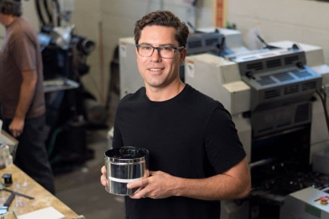 Scott in his lab, holding a flask of algae pigment—an authentic behind-the-scenes glimpse into their R&D work